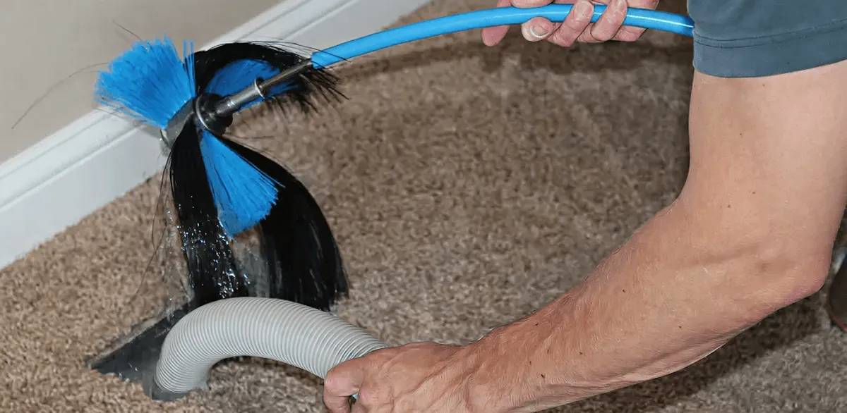 Dryer vent cleaning technician brushing lint from a vent line in Portland, OR